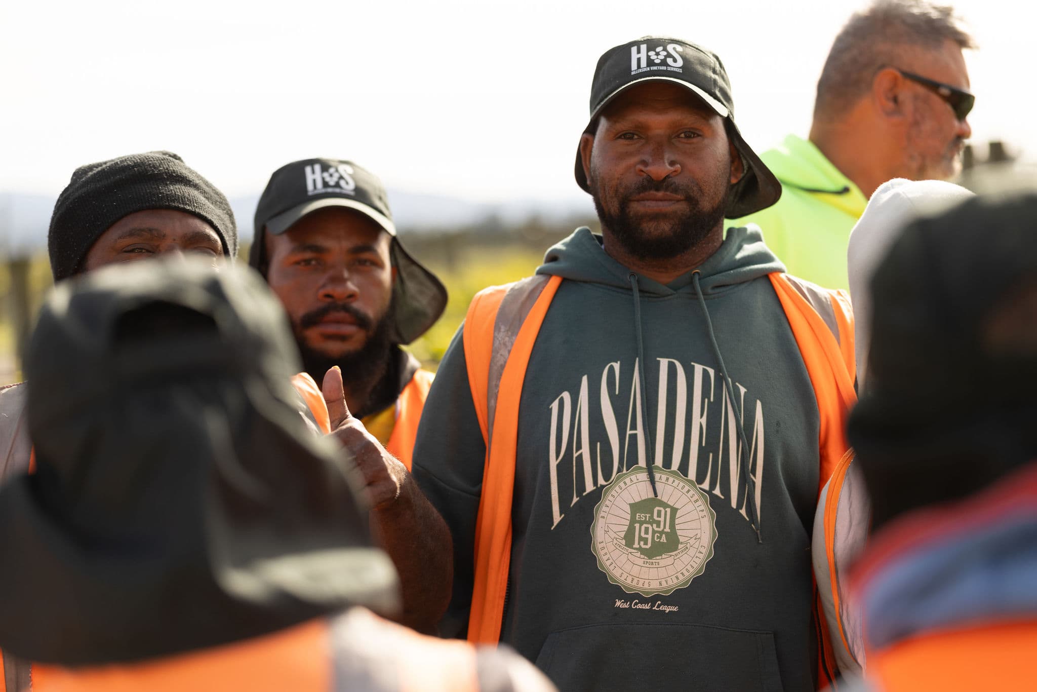 HVS team wearing branded caps in the vineyard